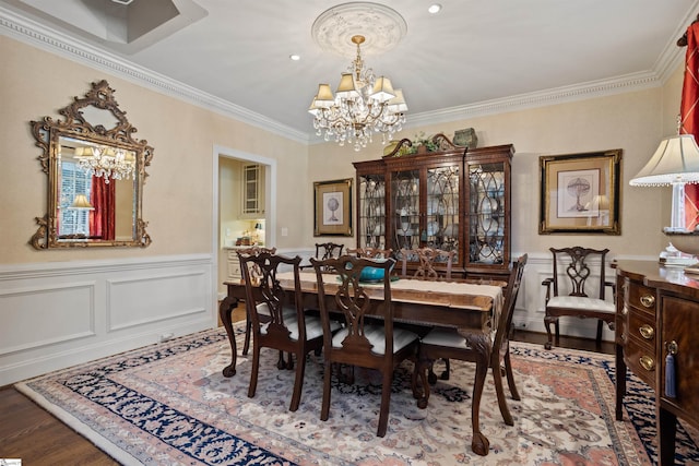 dining room with wood-type flooring, crown molding, and a notable chandelier