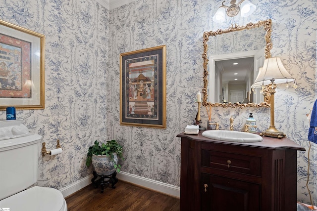 bathroom with hardwood / wood-style flooring, vanity, toilet, and ornamental molding