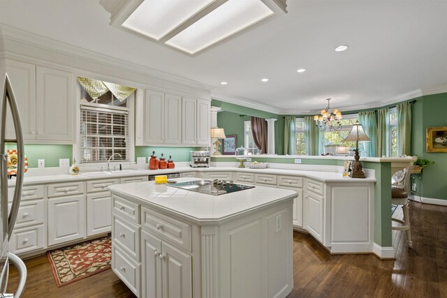 kitchen with a kitchen island, white cabinets, ornamental molding, and dark hardwood / wood-style floors