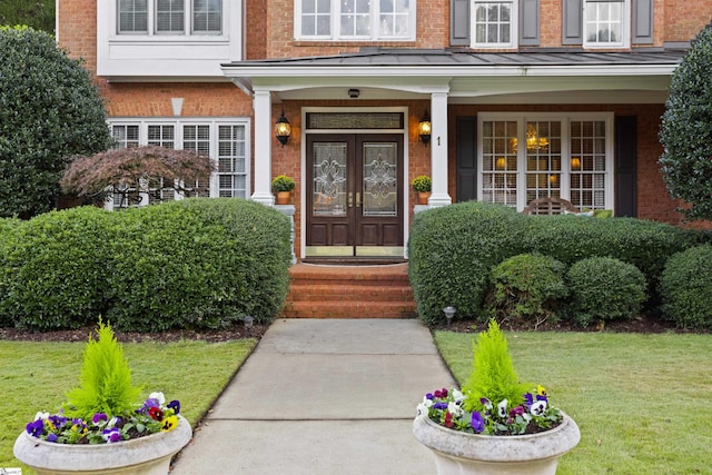 property entrance with a lawn, french doors, and a porch