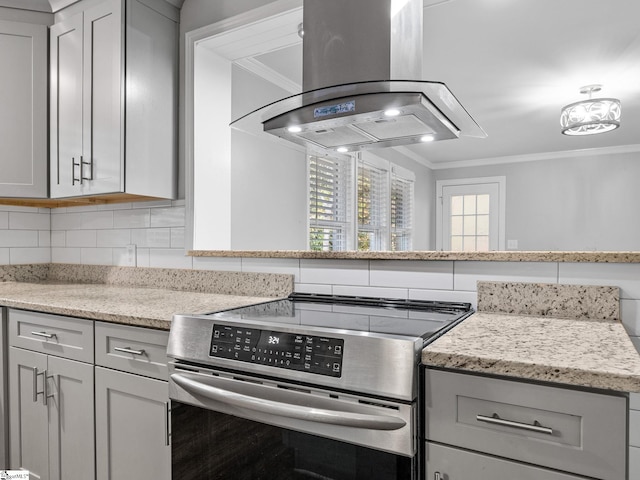 kitchen featuring island exhaust hood, stainless steel stove, gray cabinetry, and ornamental molding