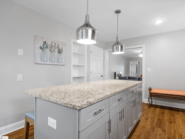 kitchen featuring hanging light fixtures, dark hardwood / wood-style floors, a center island, and gray cabinetry