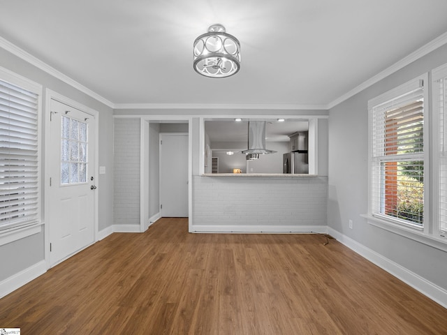 unfurnished living room featuring hardwood / wood-style flooring, a chandelier, and ornamental molding