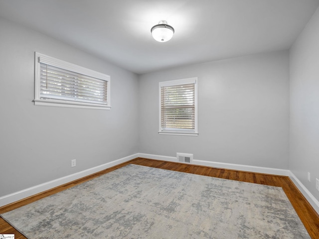 unfurnished room featuring dark hardwood / wood-style flooring