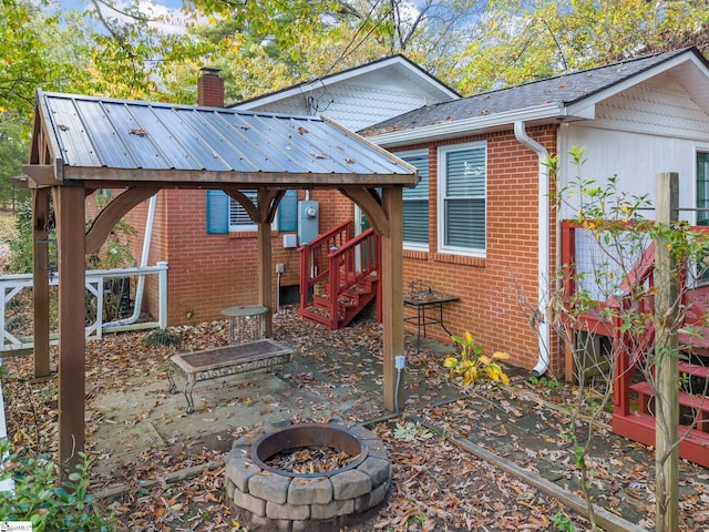 rear view of house with a patio and a fire pit