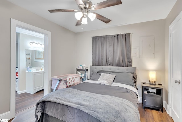 bedroom with ensuite bath, wood-type flooring, and ceiling fan