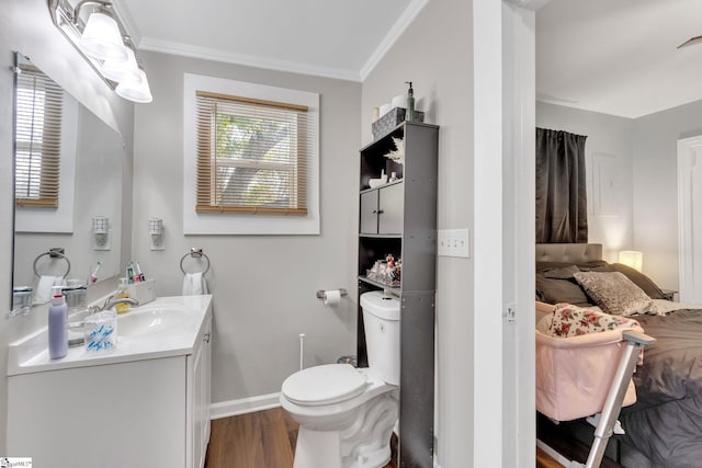 bathroom featuring toilet, vanity, hardwood / wood-style flooring, and ornamental molding