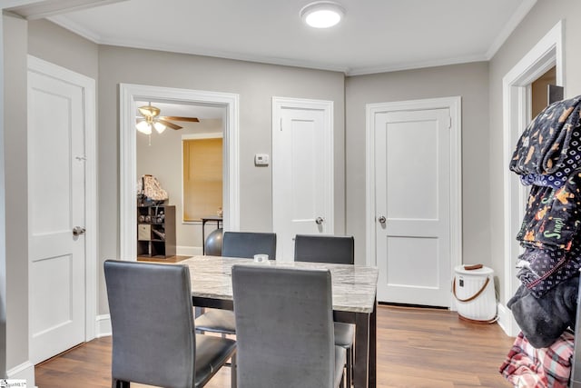 dining room featuring ceiling fan, dark hardwood / wood-style floors, and crown molding