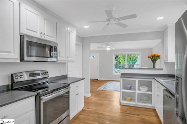 kitchen featuring stainless steel appliances, white cabinetry, kitchen peninsula, ceiling fan, and light hardwood / wood-style flooring