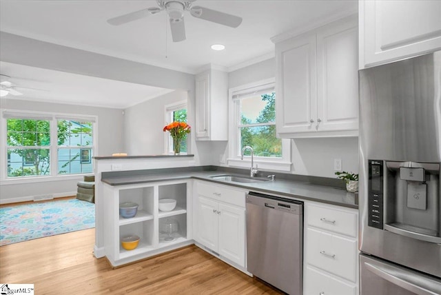 kitchen with a healthy amount of sunlight, sink, white cabinetry, and appliances with stainless steel finishes