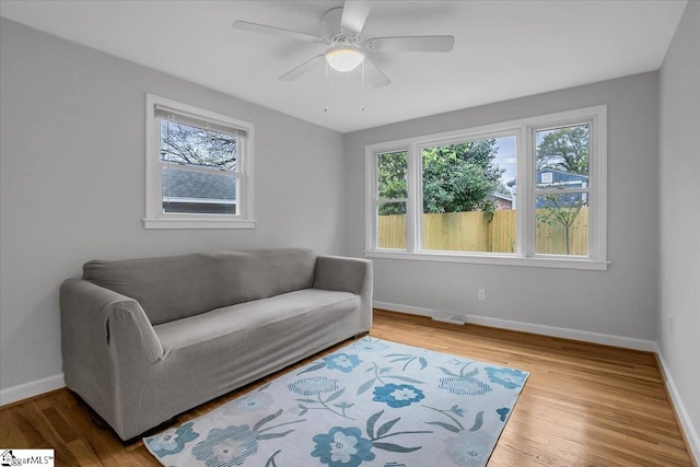 living room featuring hardwood / wood-style floors and ceiling fan