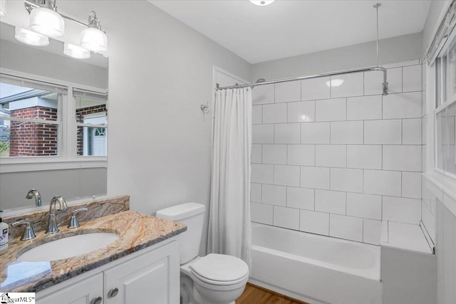 full bathroom with vanity, shower / bath combo with shower curtain, and toilet