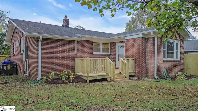 back of house featuring cooling unit, a yard, and a deck