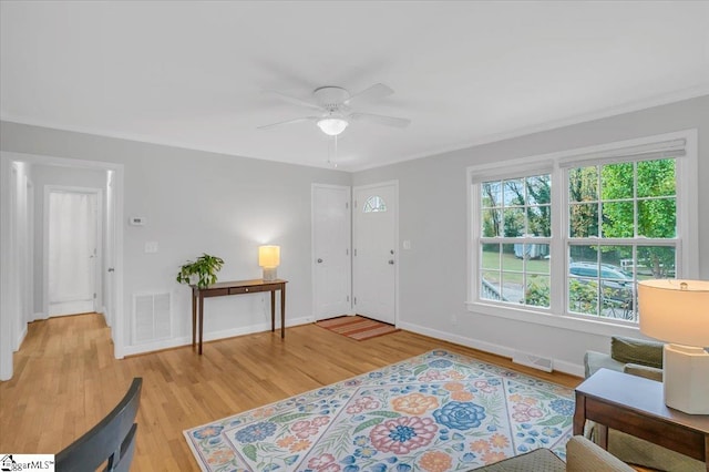 entryway featuring ceiling fan, light hardwood / wood-style flooring, and ornamental molding