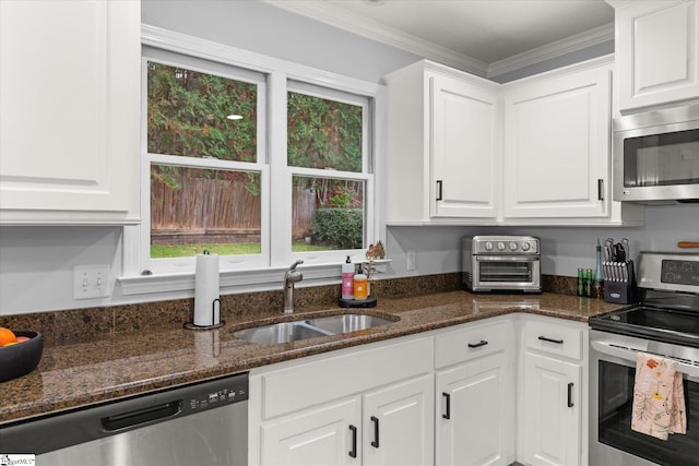 kitchen with white cabinets, stainless steel appliances, ornamental molding, and sink