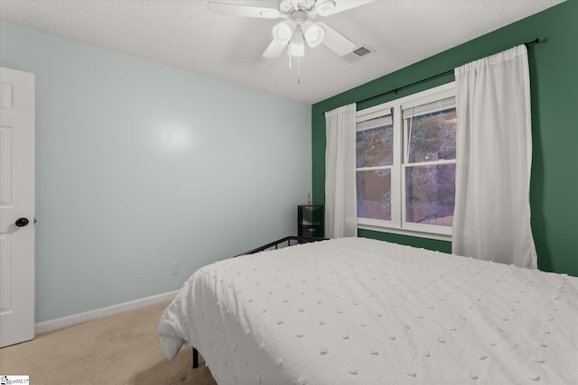 carpeted bedroom featuring a textured ceiling and ceiling fan