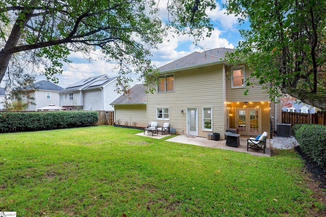 back of property with a lawn, central AC unit, a patio, and french doors