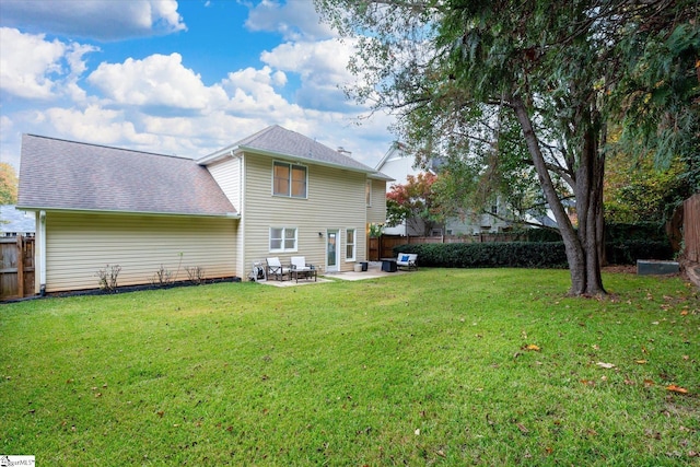 back of property with a yard and a patio