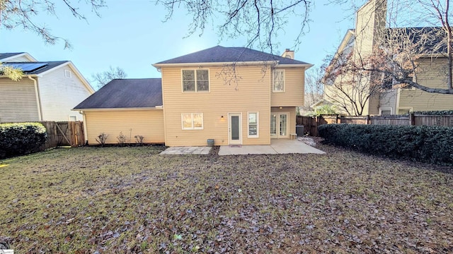 back of property with a lawn and a patio