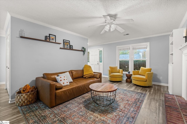 living room featuring ceiling fan, ornamental molding, a textured ceiling, and hardwood / wood-style flooring