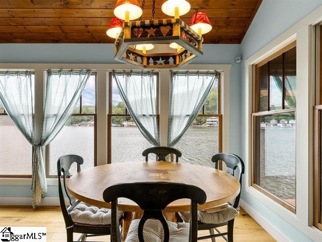 dining area with wooden ceiling, light hardwood / wood-style floors, and vaulted ceiling