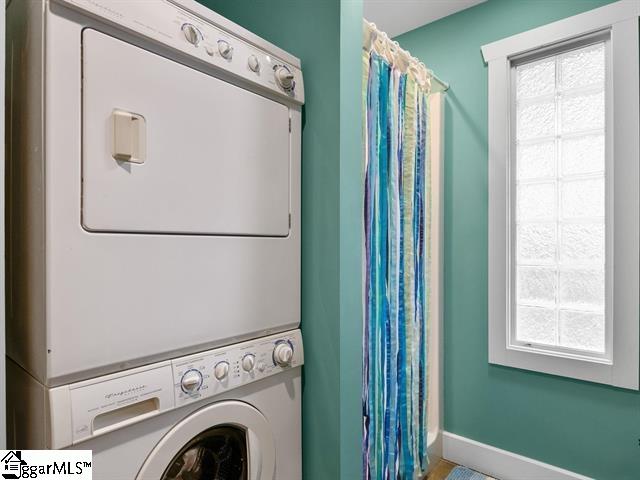 laundry room with stacked washing maching and dryer