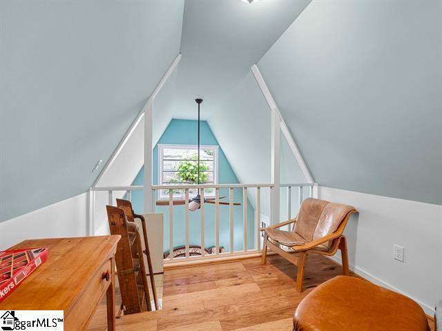 living area with light wood-type flooring and vaulted ceiling