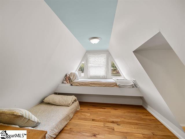 bedroom with light hardwood / wood-style floors and lofted ceiling