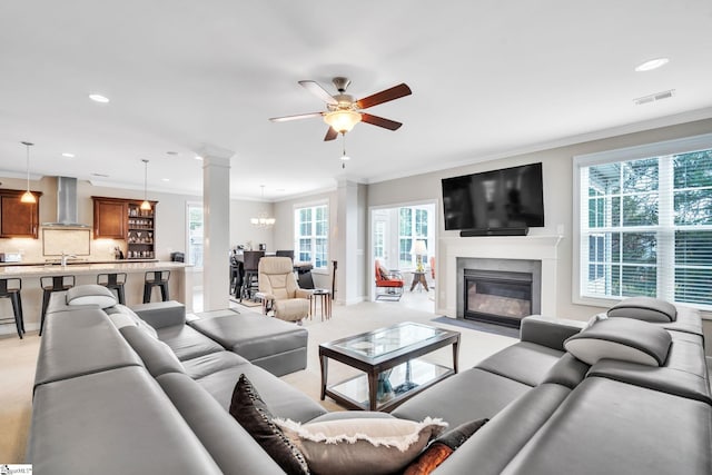 living room featuring plenty of natural light, light carpet, crown molding, and sink