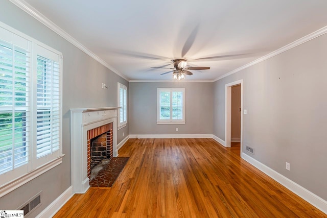 unfurnished living room with ceiling fan, hardwood / wood-style floors, ornamental molding, and a fireplace