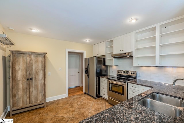 kitchen with stainless steel appliances, white cabinetry, sink, tasteful backsplash, and dark stone countertops