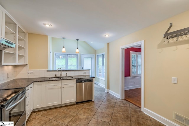 kitchen featuring stainless steel appliances, lofted ceiling, pendant lighting, sink, and white cabinetry