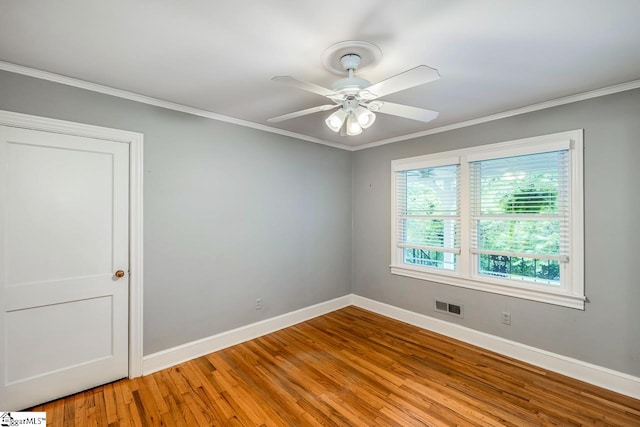 empty room with ornamental molding, wood-type flooring, and ceiling fan