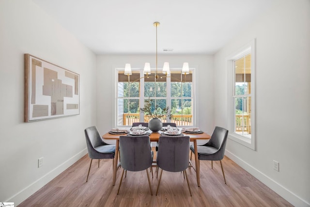 dining area featuring an inviting chandelier and light hardwood / wood-style flooring