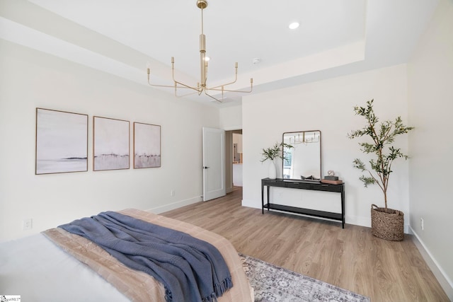 bedroom with an inviting chandelier and light hardwood / wood-style flooring