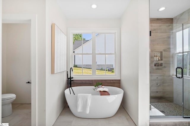 bathroom featuring independent shower and bath, tile patterned flooring, and toilet