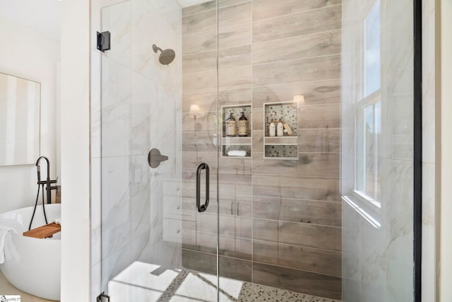 bathroom featuring shower with separate bathtub