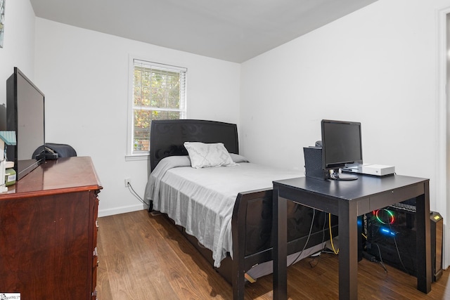 bedroom with dark wood-type flooring