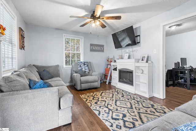 living room with a textured ceiling, dark hardwood / wood-style floors, and ceiling fan