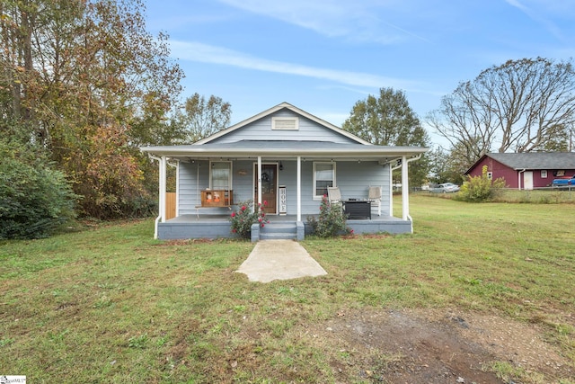 bungalow with a porch and a front lawn