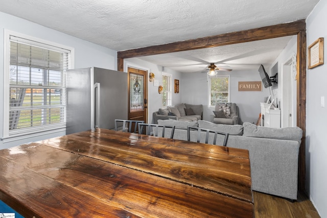 dining space with beamed ceiling, a textured ceiling, and ceiling fan