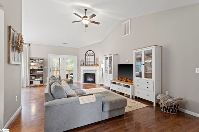 living room with dark hardwood / wood-style flooring, lofted ceiling, and ceiling fan