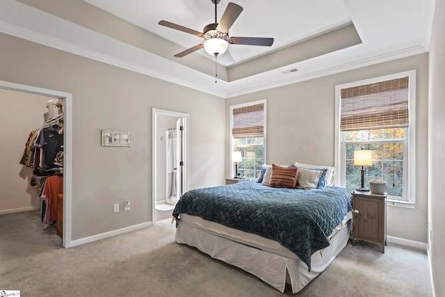 carpeted bedroom featuring a closet, multiple windows, a spacious closet, and ceiling fan