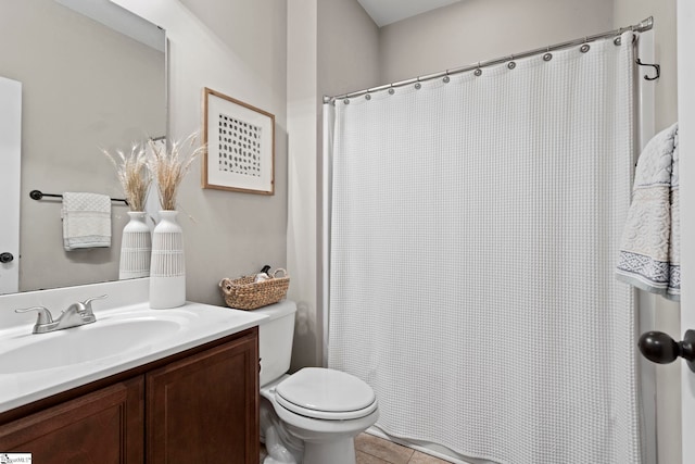 bathroom with toilet, vanity, and tile patterned flooring