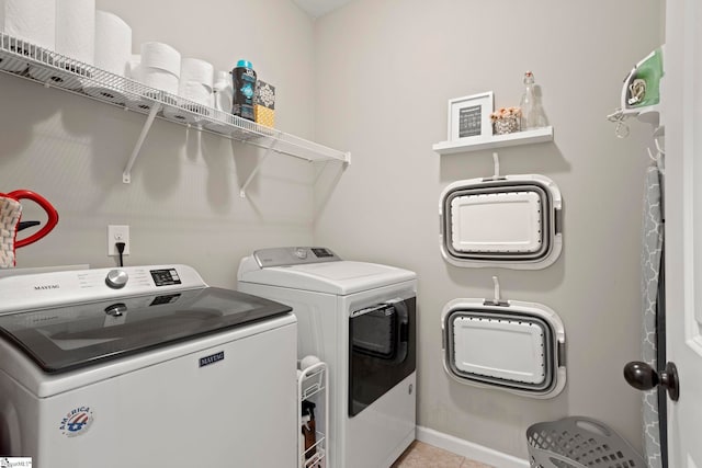 washroom with washing machine and dryer and light tile patterned floors