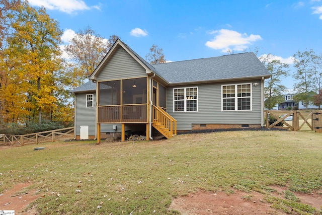 rear view of house featuring a lawn and a sunroom