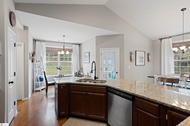 kitchen featuring light wood-type flooring, sink, dishwasher, a chandelier, and lofted ceiling