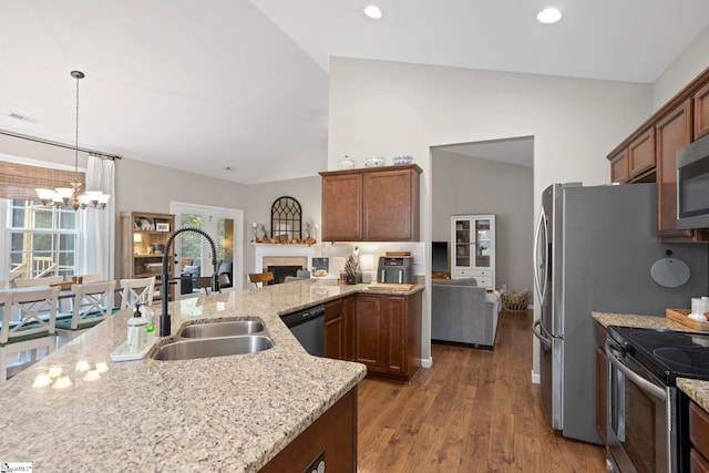 kitchen featuring stainless steel appliances, dark hardwood / wood-style flooring, lofted ceiling, a notable chandelier, and sink