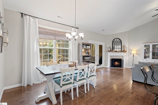 dining room featuring ceiling fan with notable chandelier and dark wood-type flooring