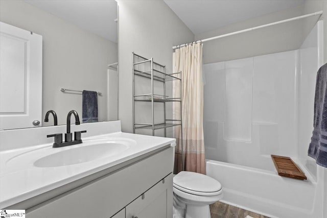 full bathroom featuring hardwood / wood-style floors, vanity, shower / bath combo, and toilet